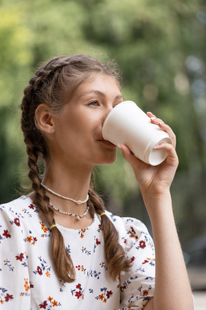 young beautiful girl drinking coffee walking around the cityの写真素材