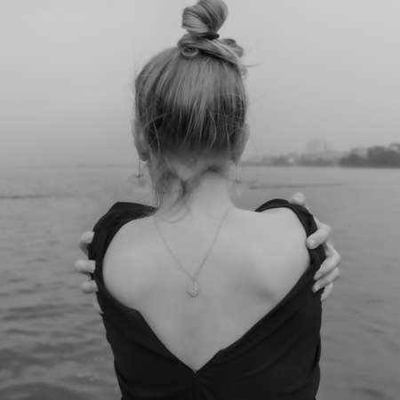 Woman on beach touch her back black and whiteの写真素材