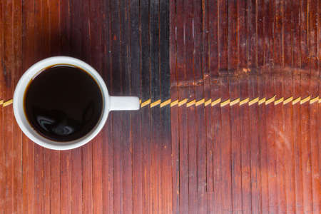 A cup of coffee on an old bamboo tableの写真素材