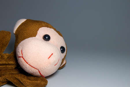 A brown monkey toy on a grey backgroundの写真素材