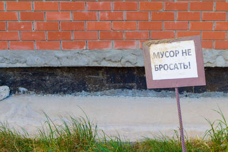 A sign on a brick wall about trash do not throw.の写真素材