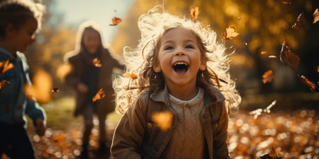 Cheerful children playing in autumn park. Kids having fun outdoors.の素材