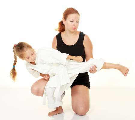 Mom teaches daughter punch kicking karateの写真素材