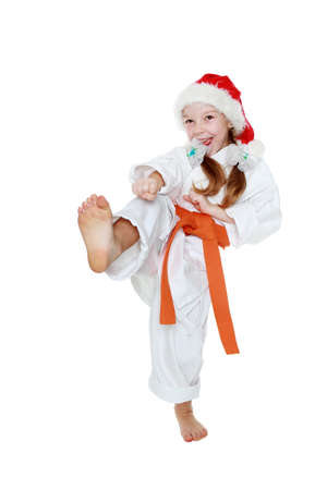 On a white background little girl in a kimono hits a kick leg insulatedの写真素材