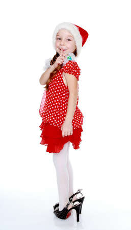 The girl in a red dress and hat of Santa Clausの写真素材