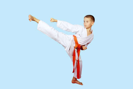 Beautiful kick foot performed by a boy with orange beltの写真素材