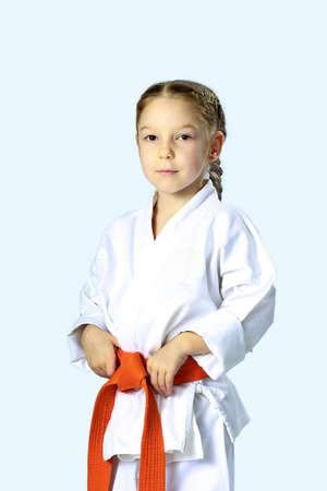 Little serious girl in a kimono with orange beltの写真素材