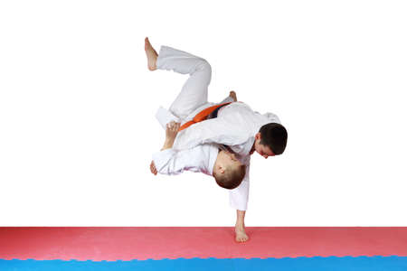 Athlete in kimono is throwing athlete with orange beltの写真素材