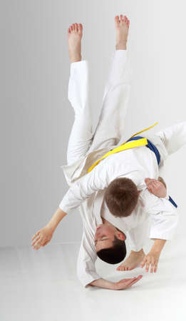 Boy with a blue belt throws boy with yellow beltの写真素材