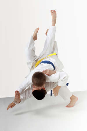 Two young athletes in kimono are performing throwsの写真素材