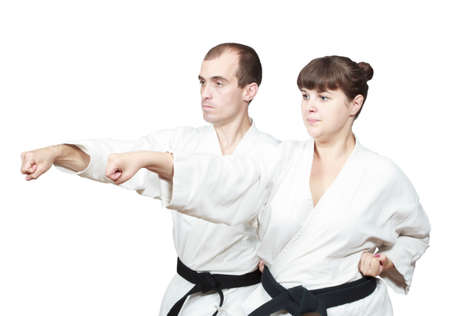 In white karategi the adult sportsmen are beating punch handの写真素材