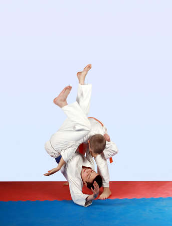 Performing throw athlete in kimono with orange beltの写真素材