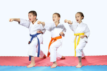 Three sportsman in karategi are hitting blows armsの写真素材