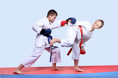On the red and blue mats athletes  are doing paired exercises karateの写真素材