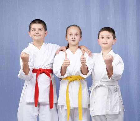 Boy and girl standing in rack of karate and showing the finger superの写真素材