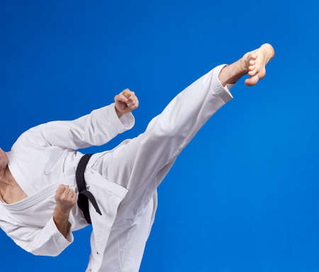 High kick athlete is beating with a black beltの写真素材