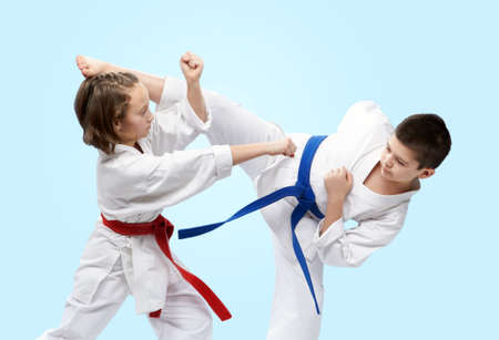 On a light background athletes train blocks and kicks of karateの写真素材