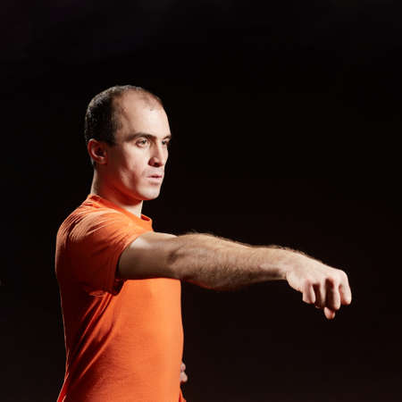 Adult man training a hand stroke on a black background