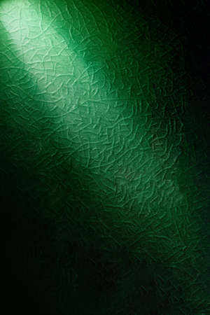 Light green diagonal ray of light on a background with a diverse pattern