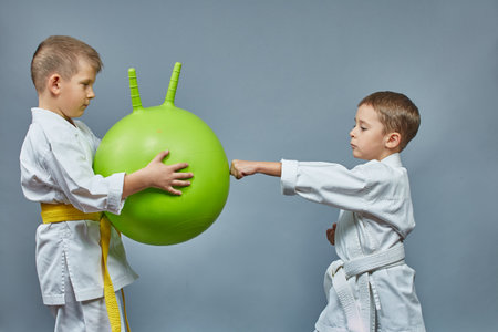 The boy hits the green ball with his handの写真素材