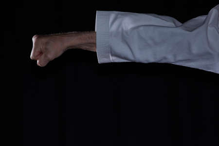 Hand punch performed by an athlete against a dark backgroundの写真素材