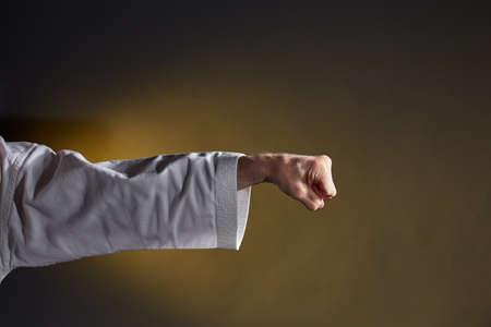 On a yellow background, punch and block hand in karategiの写真素材