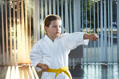 A small athlete trains a punch in karategiの写真素材