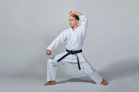 On a gray background, a young athlete trains a formal karate exerciseの写真素材
