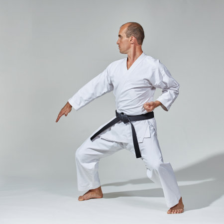 A young athlete with a black belt does formal karate exercisesの写真素材