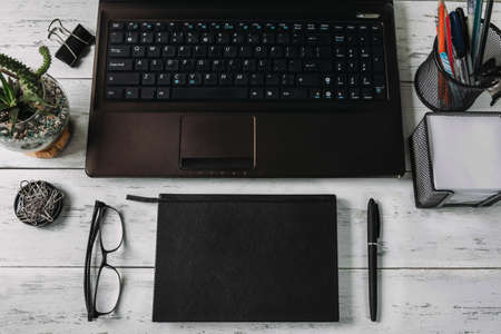 Close-up of a work desk in an office or home office. Office supplies on a wooden table. Glasses,...