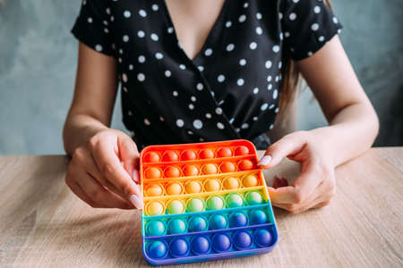 Young girl dressed in a dress with polka dots holds anti-stress toysの写真素材