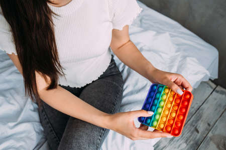 Young girl sitting on the bed plays