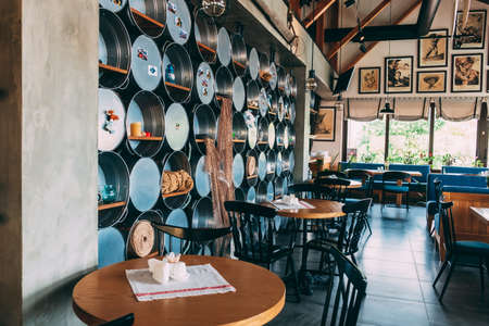 ZATOKA, UKRAINE - JUNE 14 2021: The interior of the restaurant's pub is in a modern retro style with a predominance of wood and metal finishes. Metal basins hang on the wallのeditorial素材
