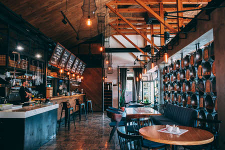ZATOKA, UKRAINE - JUNE 14 2021: The interior of the restaurant's pub is in a modern retro style with a predominance of wood and metal finishes. Left bar and grill counterのeditorial素材