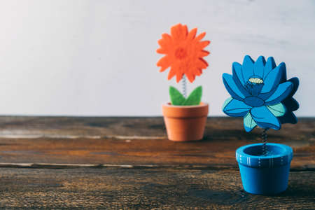 Two holders for notes in form of a flower in pot on wooden backgroundの写真素材