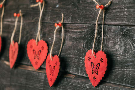 Wooden hearts on a thread. Close-ups of a doe hang on a wooden wall. Love and relationships