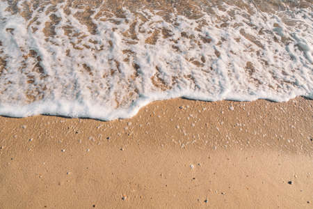 Top view of coastline. Tide of wave. Wave foam. Golden sea sandの写真素材