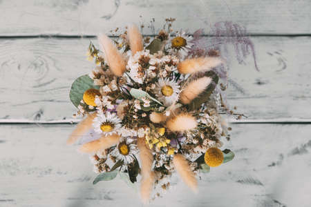 Top view of bouquet of dried flowers on white wooden table. Beautiful bouquet for interior.の写真素材