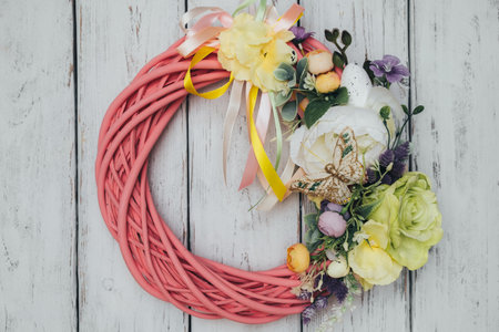 Festive handmade Easter wreath hanging on wooden white door. holiday decoration.の写真素材