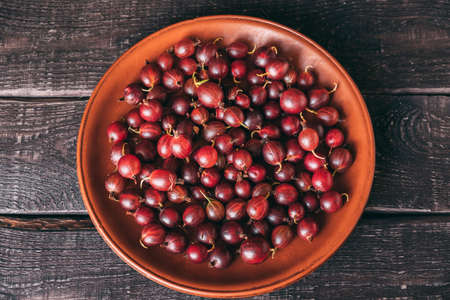 Top view of plate filled with ripe red gooseberriesの写真素材