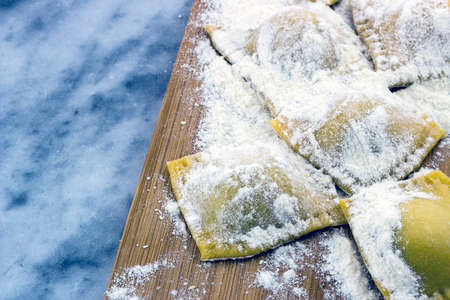 Floured italian ravioli with black pepper on a marble backgroundの写真素材