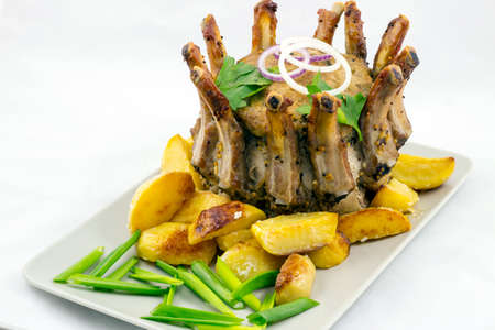Crown roast of pork with potato wedgesの写真素材
