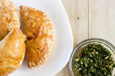 Empanadas in white plate on light wood backgroundの写真素材