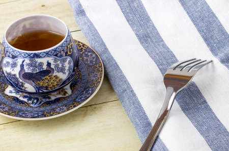 Cup of tea with napkin on light wood backgroundの写真素材