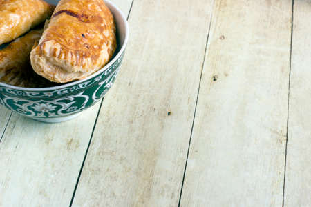 Empanadas in green plate on light wood backgroundの写真素材