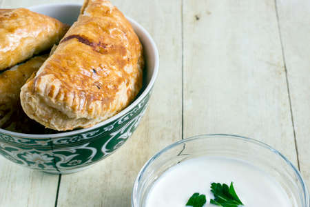 Empanadas in green plate on light wood backgroundの写真素材