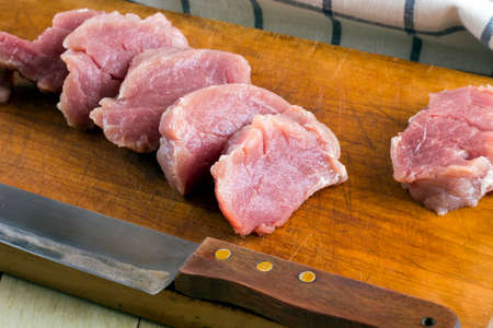 Cut fresh pork on wood board with background of salt and black pepperの写真素材