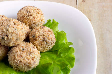 Cheeseballs in white plate on light wood backgroundの写真素材