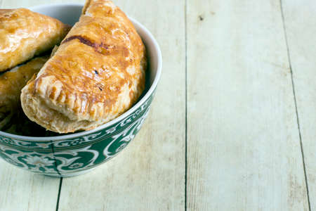Empanadas in green plate on light wood backgroundの写真素材