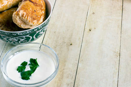 Empanadas in green plate on light wood backgroundの写真素材